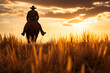 Cowboy Riding through the field into the Sunset