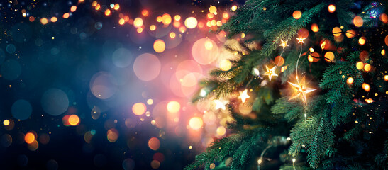Wall Mural - christmas tree with lights in blue - stars hanging on fir branches with glittering and bokeh in abst