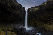 Nighttime Waterfall Under Starry Sky At Night In Iceland