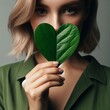 beautiful woman  holding a heart shaped leaf .eco concept