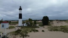 Big Sable Lighthouse On Lake Michigan. Aerial Flyover Of The Site, Showing The Fog Horn, Lighthouse And Keepers House, From Offshore To Onshore. Lower Shot, Approximately Midheight Of The Lighthouse.