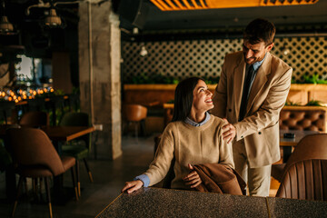 Wall Mural - Man and woman discussing strategy in a cafe, preparing for a meeting with focused attention