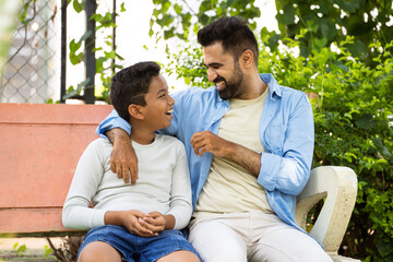 Wall Mural - Happy indian father with son spending time at park during weekend holidays