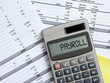 Calculating the payroll concept. Staff wages. The word payroll on a calculator.