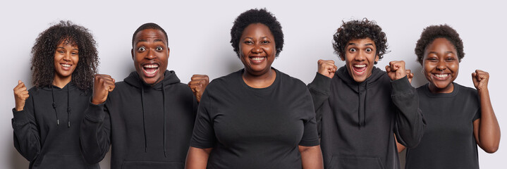 Wall Mural - Collage image of happy mixed race young people clench fists celebrates success dressed in casual black clothing stand next to each other isolated over white background. People enjoy triumph.