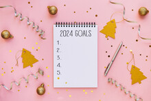 New Year Resolutions 2024 On Desk. 2024 Goals List With Notebook On Festive Pink Background. Resolutions, Plan, Goals, Actions, Checklist, Idea Concept