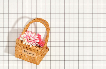 A beautiful decorative wicker basket with flowers. Top view, copy space for text.