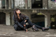 Asian woman in emo goth clothes at an abandoned building