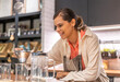 Portrait of barista woman small business owner working behind the counter bar and  receive order from customer on coffee packaging and cup of coffee background in cafe or coffee shop