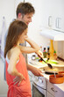 © Alexandra/peopleimages.com - Young, couple and cooking of dinner in kitchen, together and bonding for relationship. Man, woman and talking by stove by preparation of yummy, delicious or meal for health, nutrition or diet in home