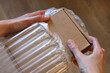 Hands holding a small parcel in an inflatable translucent package