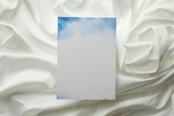 Wall Mural - Blank invitation card on white fabric, top view