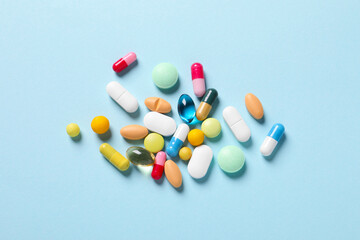 Wall Mural - Many different pills on light blue background, flat lay