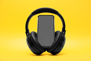 Wall Mural - Modern wireless headphones and smartphone on yellow background