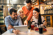 © Mediteraneo - Young friends looking at digital tablet while sitting in cafe.
