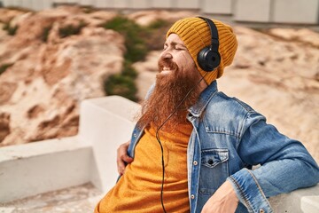 Poster - Young redhead man smiling confident listening to music at street