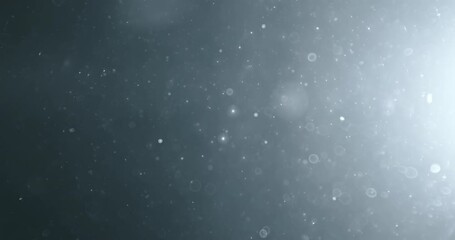 Floating abstract particle bokeh on dark background