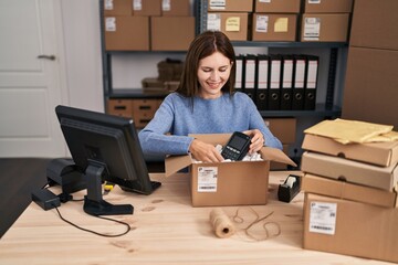 Canvas Print - Young blonde woman ecommerce business worker packing data phone on cardboard box at office