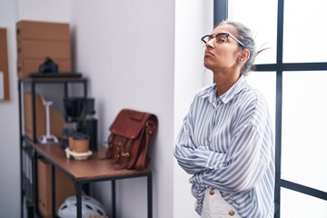 Canvas Print - Young beautiful hispanic woman business worker standing with arms crossed gesture at office