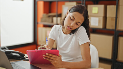 Wall Mural - African american woman ecommerce business worker talking on smartphone writing on document at office