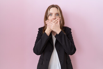 Canvas Print - Young caucasian business woman wearing black jacket shocked covering mouth with hands for mistake. secret concept.