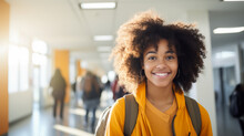 A Young African American Teenager In A College Hallway. A Smiling Dark-skinned Student Looks At The Camera. Education Concept.