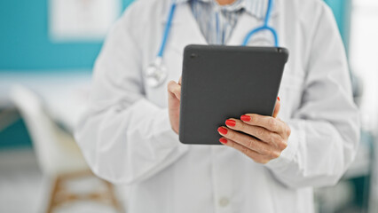 Wall Mural - Middle age woman doctor using touchpad at clinic