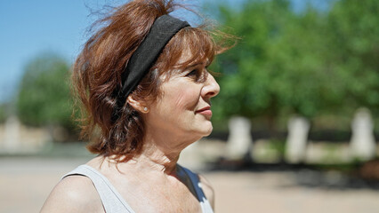 Canvas Print - Middle age woman looking to the side with serious expression at park