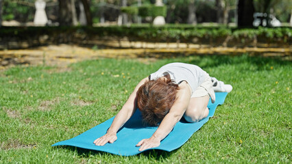 Sticker - Middle age woman stretching back on yoga mat at park