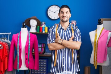 Sticker - Young hispanic man tailor smiling confident standing with arms crossed gesture at sewing studio