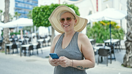 Sticker - Middle age grey-haired woman tourist smiling confident using smartphone at coffee shop terrace