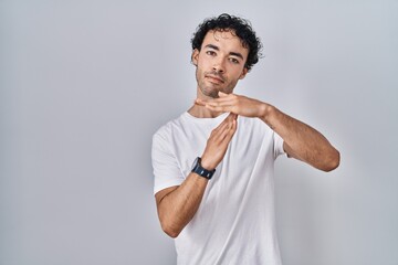 Sticker - Hispanic man standing over isolated background doing time out gesture with hands, frustrated and serious face