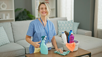 Poster - Young blonde woman professional cleaner cleaning table smiling at home