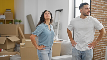 Wall Mural - Man and woman couple standing together looking around at new home