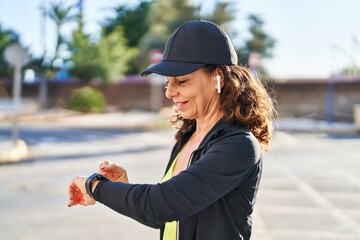 Sticker - Middle age hispanic woman working out with smart watch outdoors