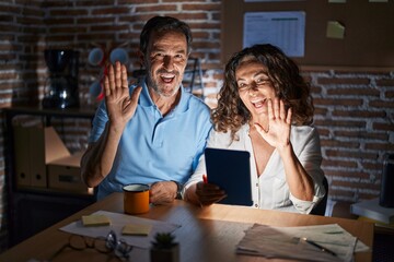 Sticker - Middle age hispanic couple using touchpad sitting on the table at night waiving saying hello happy and smiling, friendly welcome gesture