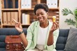 African american woman working on depression holding pills smiling happy pointing with hand and finger to the side