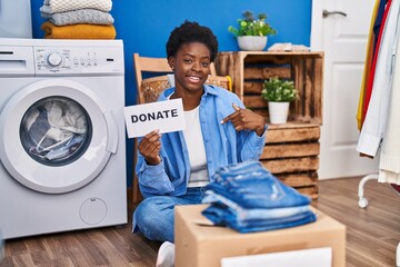 Sticker - African american woman donating clothes pointing finger to one self smiling happy and proud