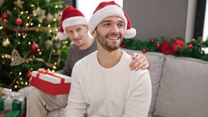 Sticker - Two men couple celebrating christmas holding gift at home