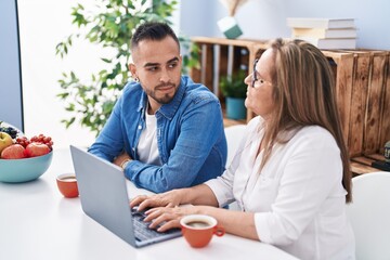 Poster - Man and woman mother and son drinking coffee using laptop at home