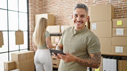 Sticker - Man and woman ecommerce business workers using touchpad checking packages at office