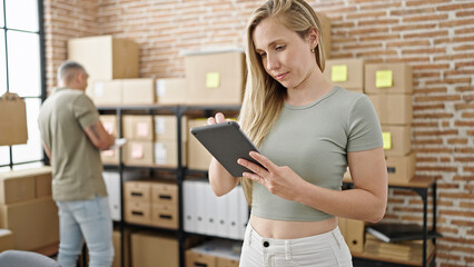 Poster - Man and woman ecommerce business workers using touchpad checking packages at office