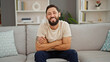 © Krakenimages.com - Young hispanic man smiling confident sitting on sofa with arms crossed gesture at home