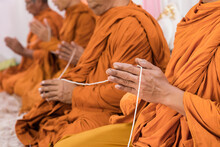 Close Up Monk's Hand Holding Holy Thread, Thai Buddhist Monks Praying In Temple At Buddhist Temple Holding Sacred Cord Or Holy Thread Press The Hands For Worship In Buddhism Religious Ceremony.