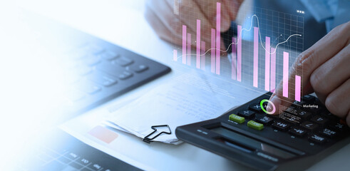 Wall Mural - businessman using calculator with marketing data growth graph and progress of business and analyzing
