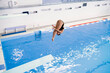 olympic sport, sports diving in the swimming pool, female athlete doing spin in the air