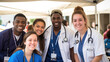 © Studio Nova - Healthcare professionals in blue scrubs, wearing stethoscopes and ID badges, smile warmly as they stand together in a tented medical setting.