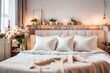Double bed with pillows in interior of intimate bedroom in flat in light style apartments with still life decoration from two empty wine glasses, home-made rag angel toy and bouquet of dried flowers