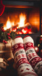 © Moon Project - Feet in woolen socks by the Christmas fireplace. Person relaxing by the fire with a cup of hot drink. Close-up. Concept of winter vacations and Christmas.