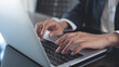 © tippapatt - Close up of business woman hand typing on laptop computer keyboard with reflection on digital tablet on office table, online working, surfing the internet, distant job, remote work concept